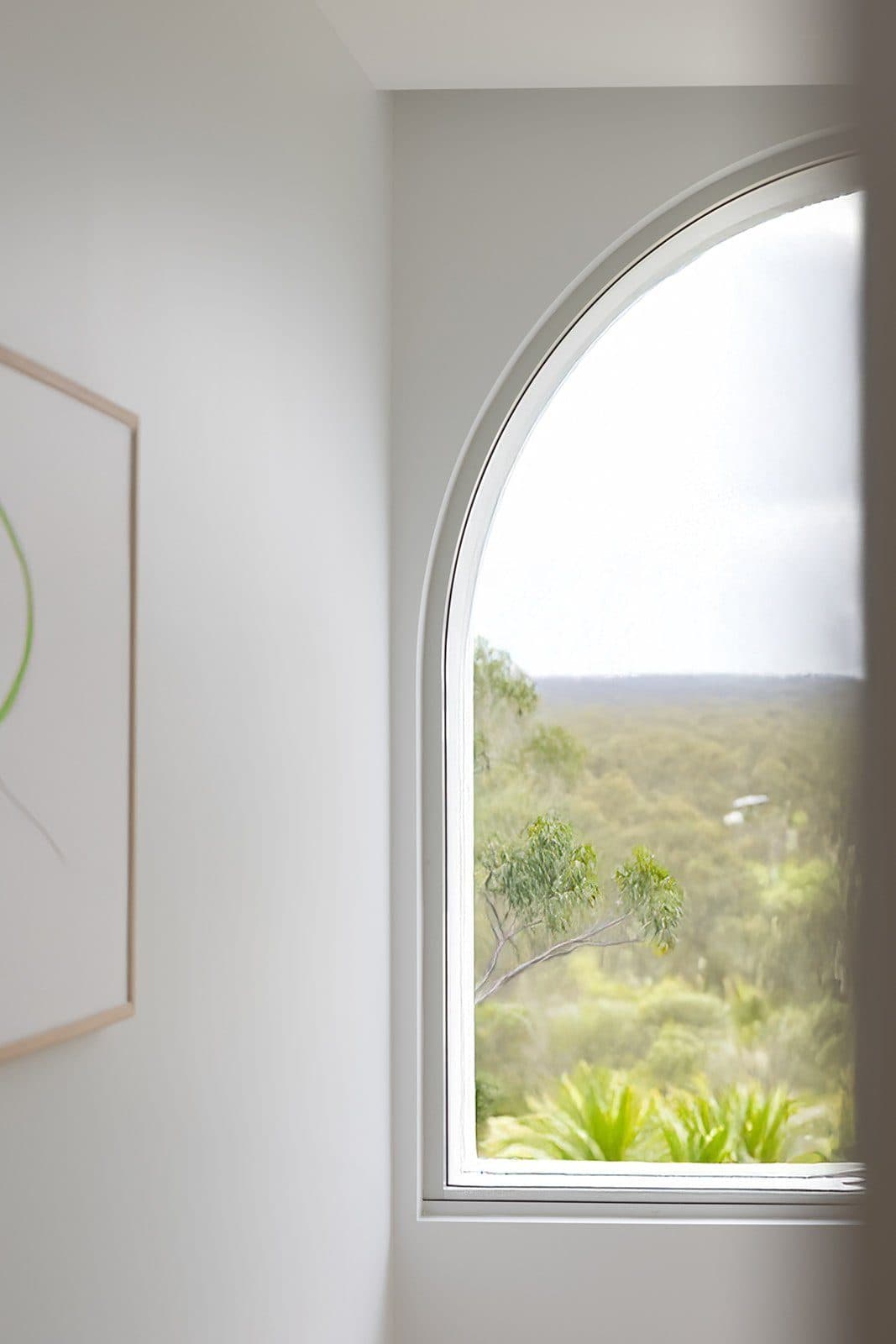 Arched window framing the coastal bushland