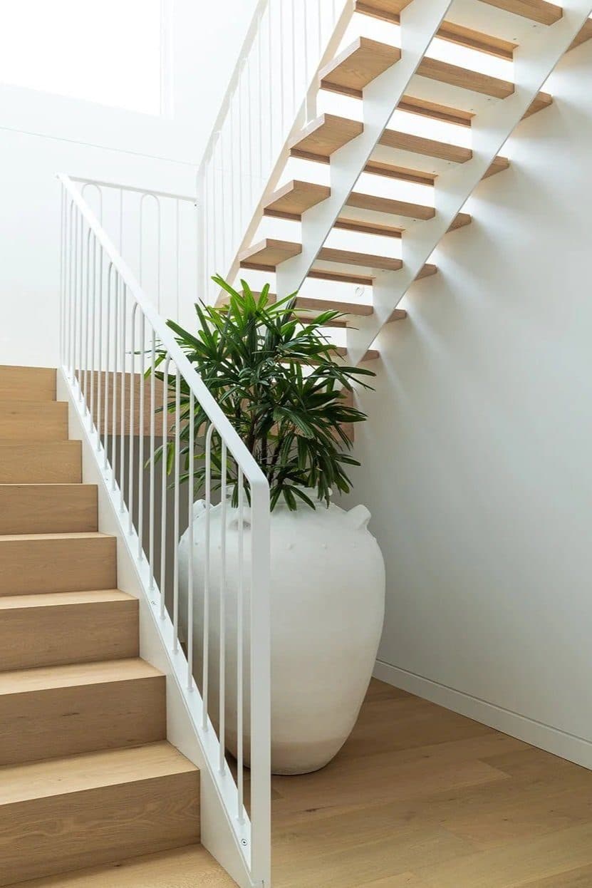 Oak staircase with white balustrade and sculptural planter