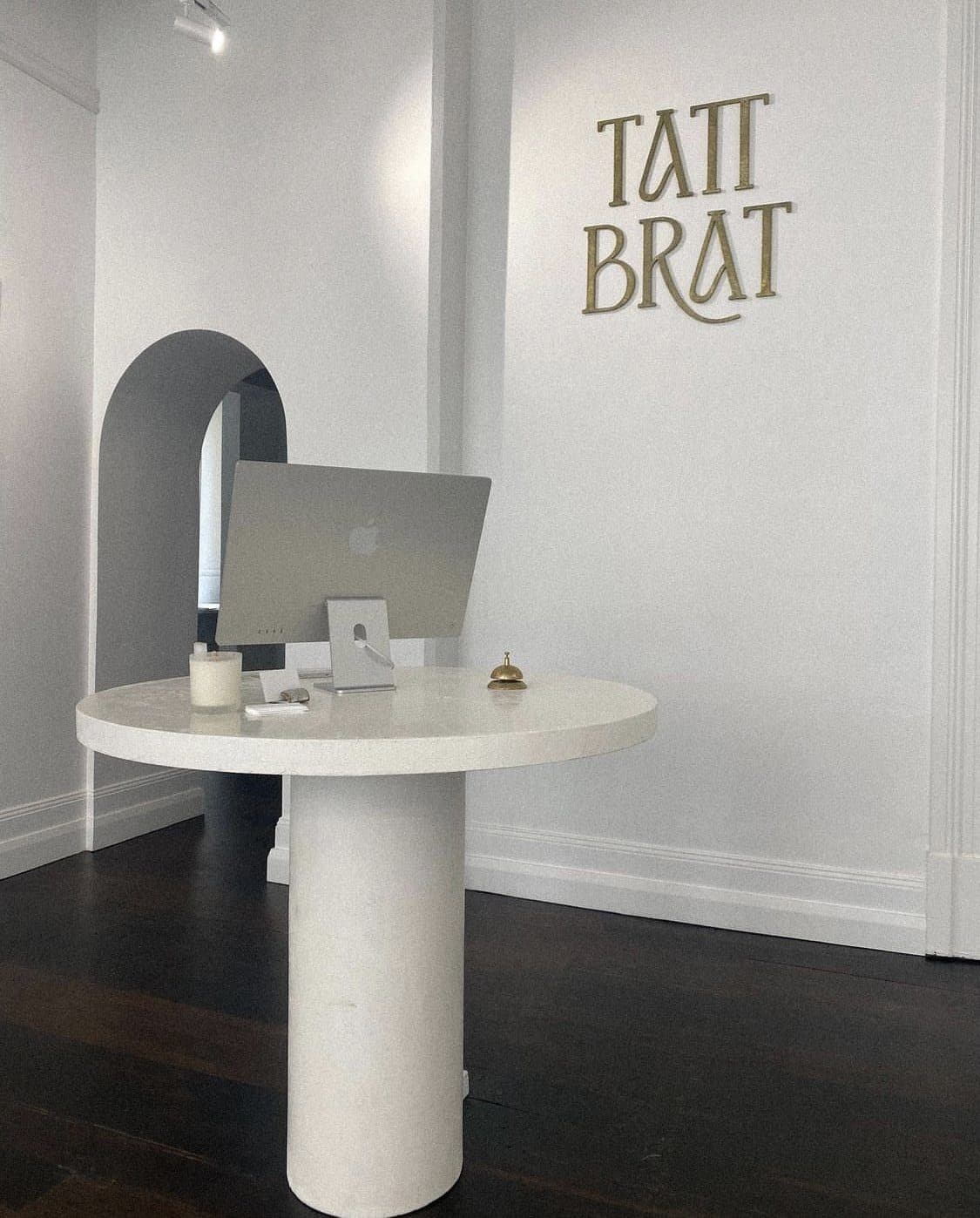 Reception desk under the arch with the Tatt Brat mark