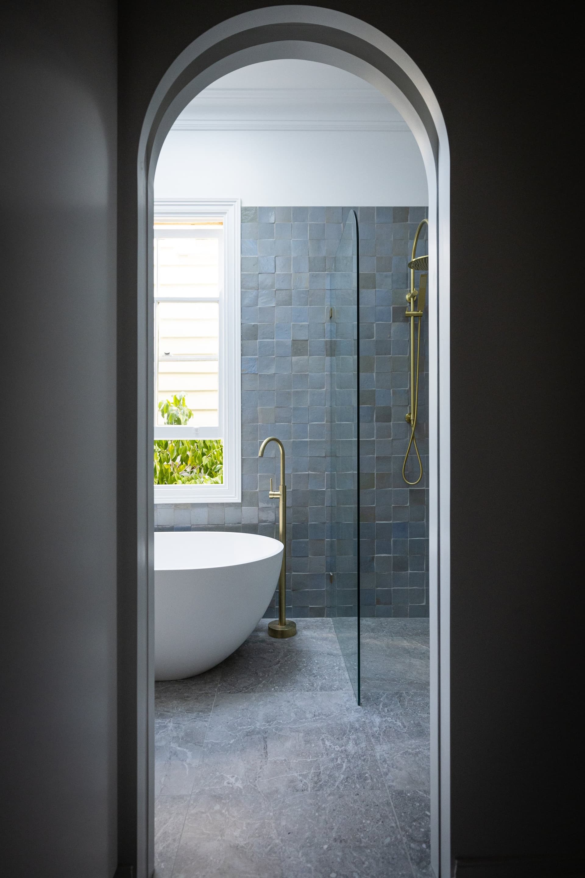 Arched doorway to the freestanding bath and walk-in shower