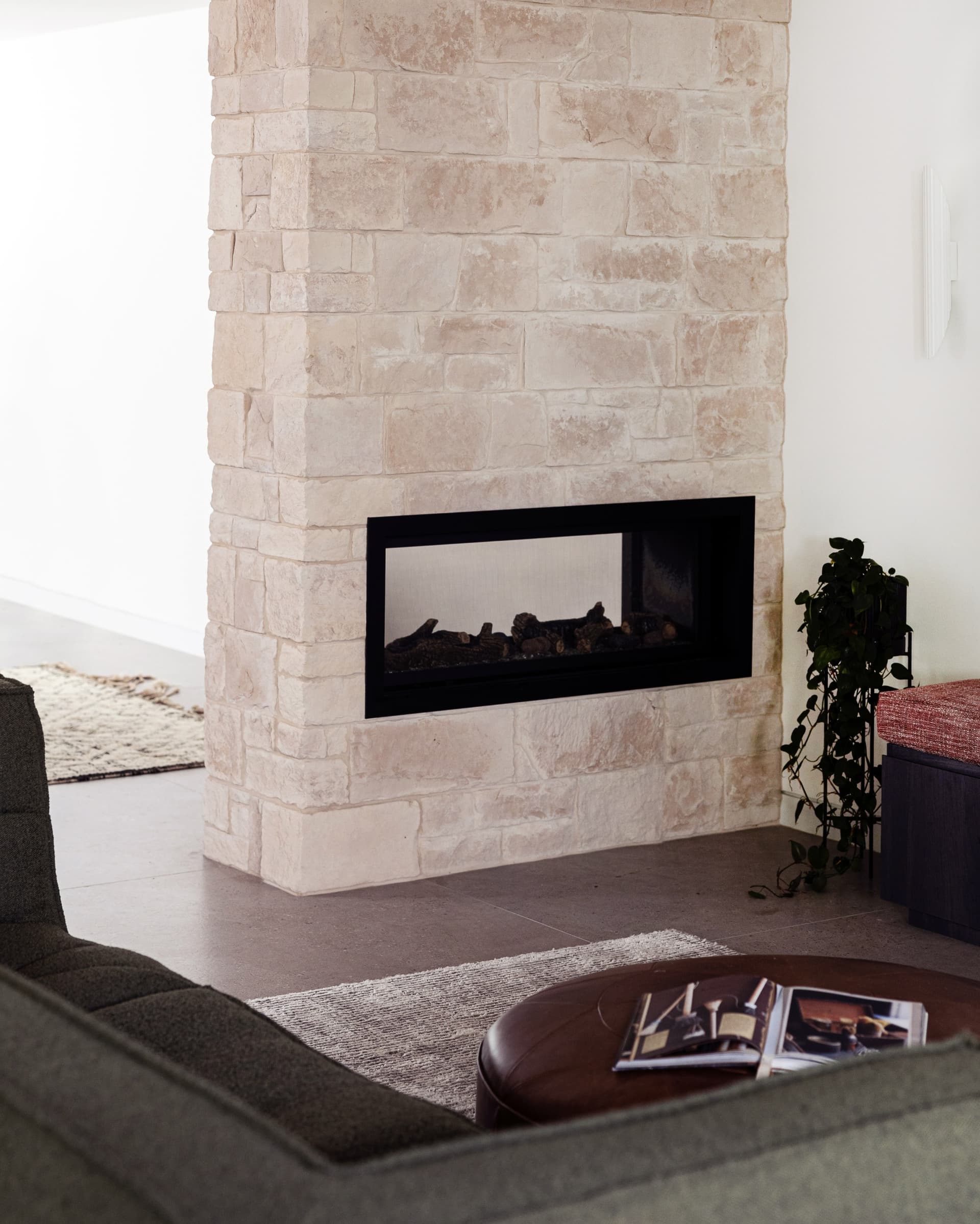 Double-sided sandstone fireplace between living and dining