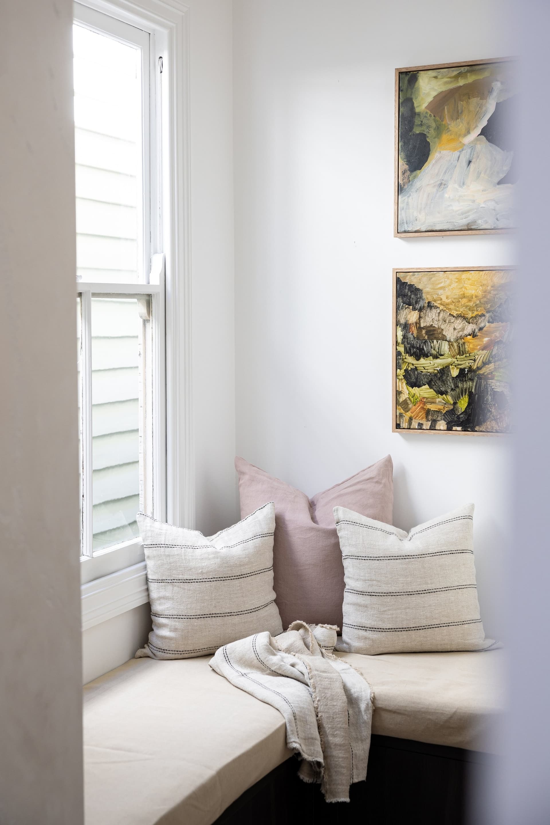 Restored bay-window seat with cushions in the heritage front rooms