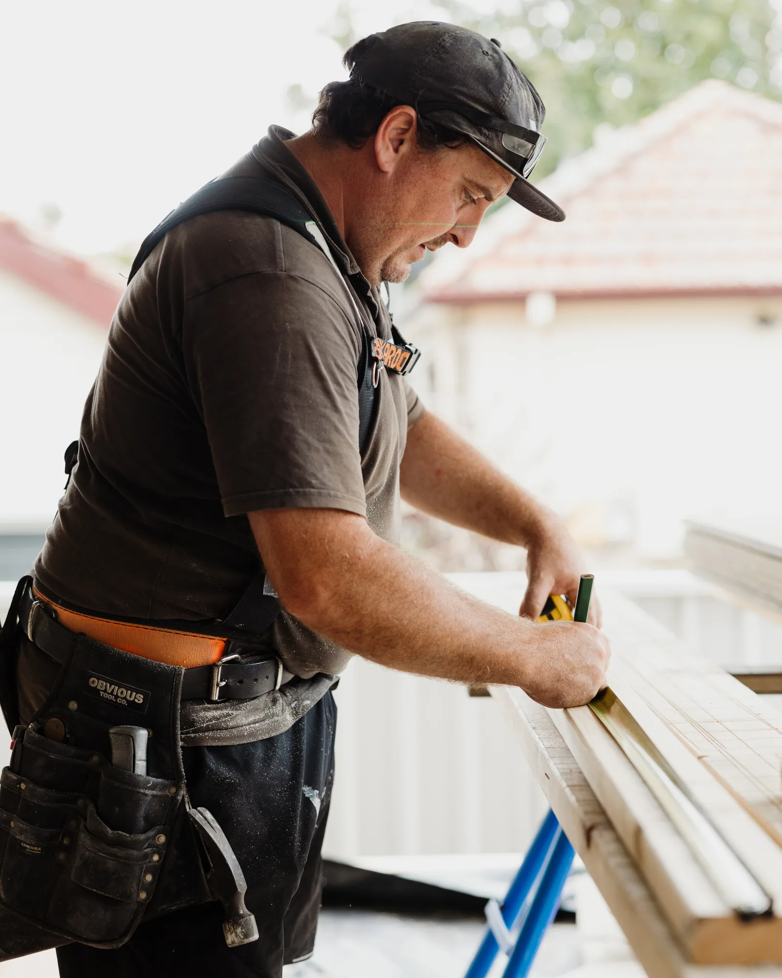 An MBC carpenter marking out a length of timber on site