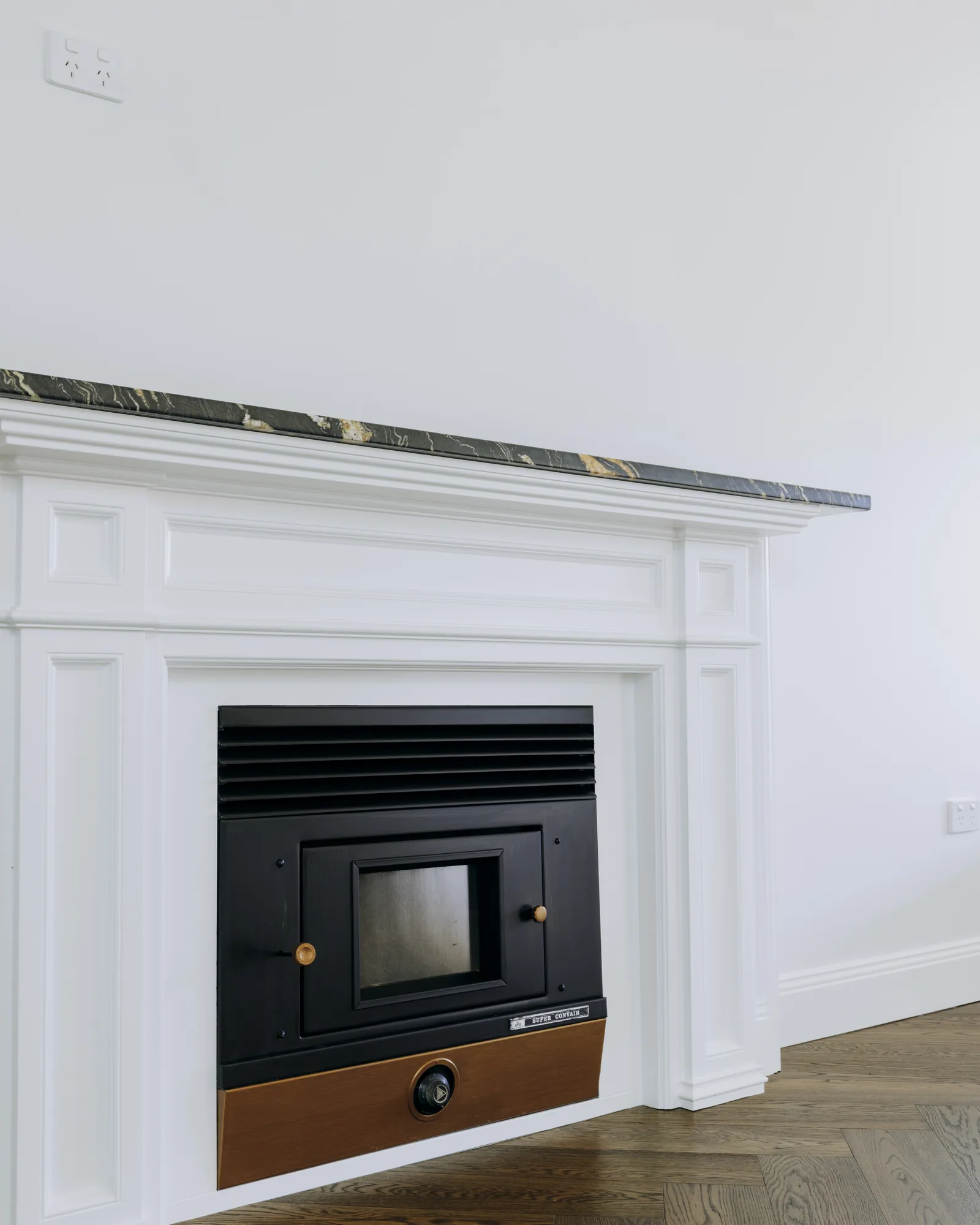 Restored fireplace with marble hearth and timber mantel in the finished Mayfield renovation