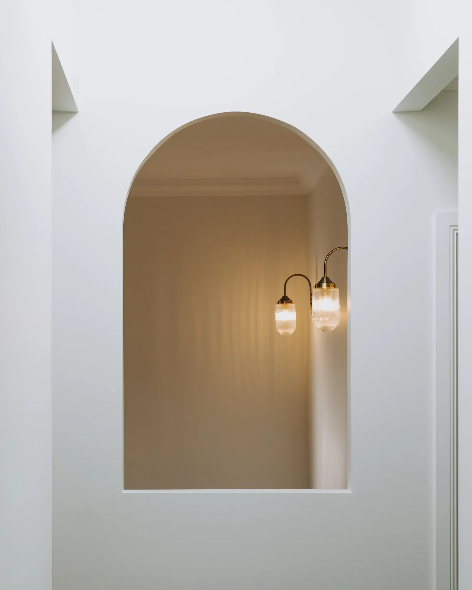Arched wall niche with twin wall lights in the finished Mayfield renovation